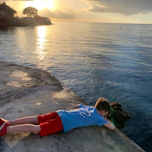 Boy on wall at sunset